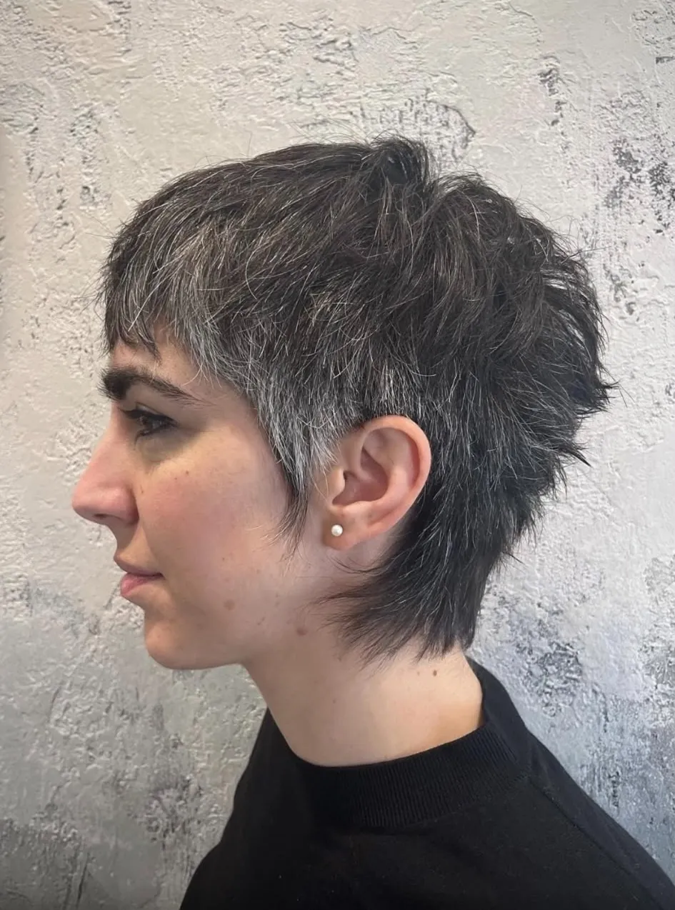 Taglio corto scalato su capelli scuri con fili bianchi